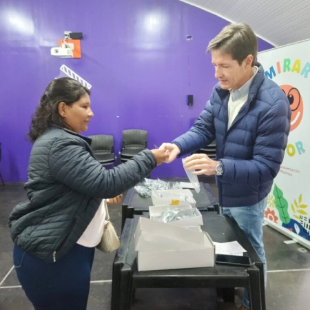 Héctor Decut entrega anteojos a una vecina durante el operativo "Mirar mejor" en Cerro Azul.