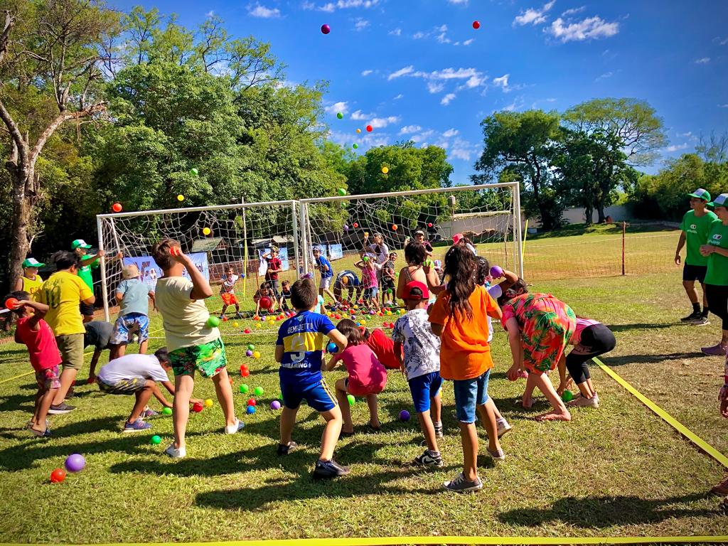 equipos de niños enfrentados juegan competencia con pelotitas de colores